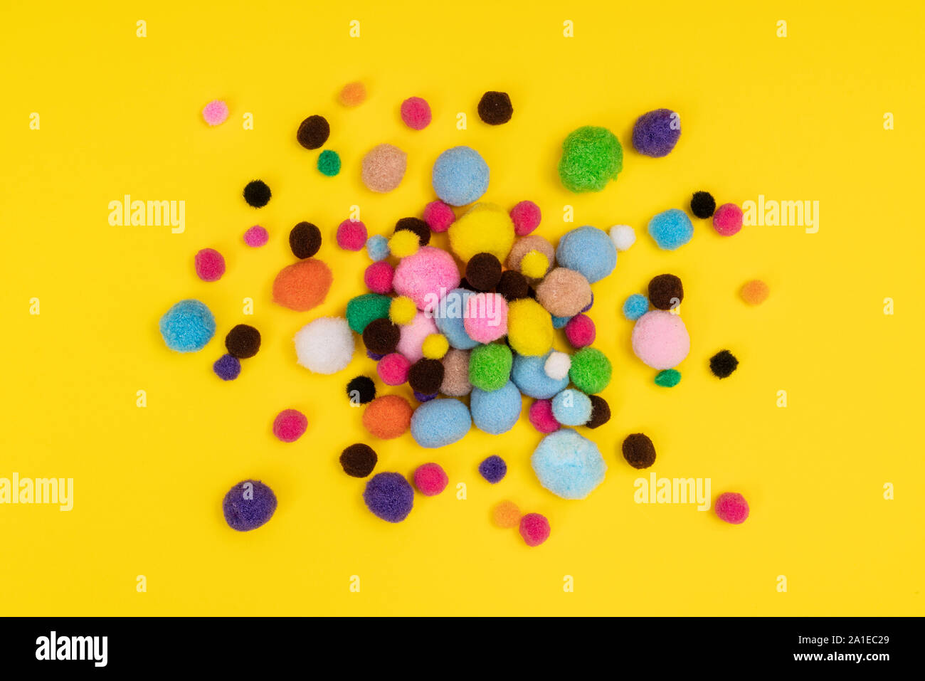 Alcune palline di feltro di diversi colori su una superficie colorata Foto Stock