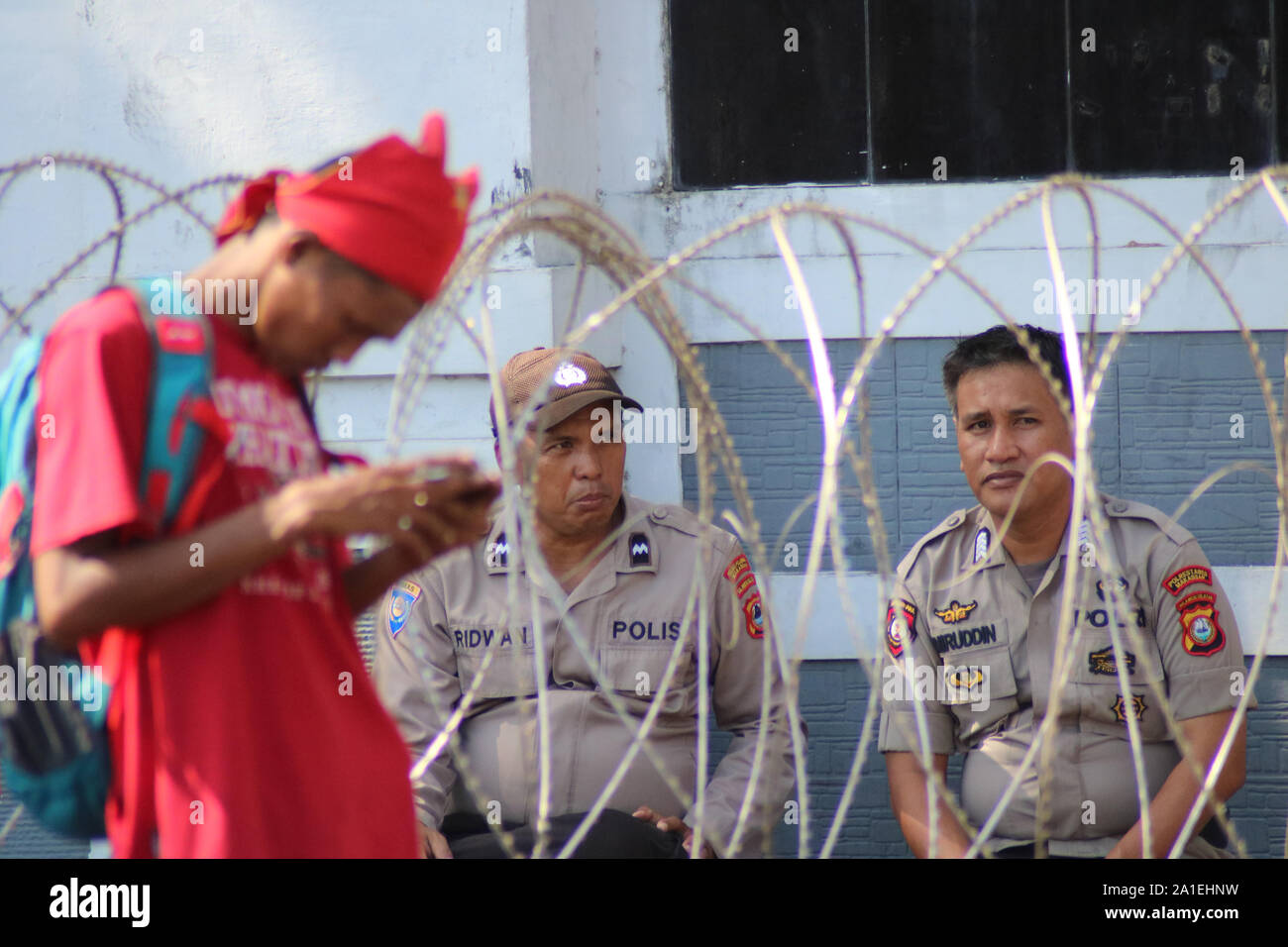 Makassar, Indonesia, 26 settembre 2019. Due poliziotti sono stati seduti dietro il filo spinato che era stato installato nella parte anteriore del Sud Sulawesi DPRD Office. Le forze di polizia sono state in guardia perché molti studenti hanno dimostrato a respingere la revisione della legge KPK. Credito: Herwin Bahar/Alamy Live News Foto Stock