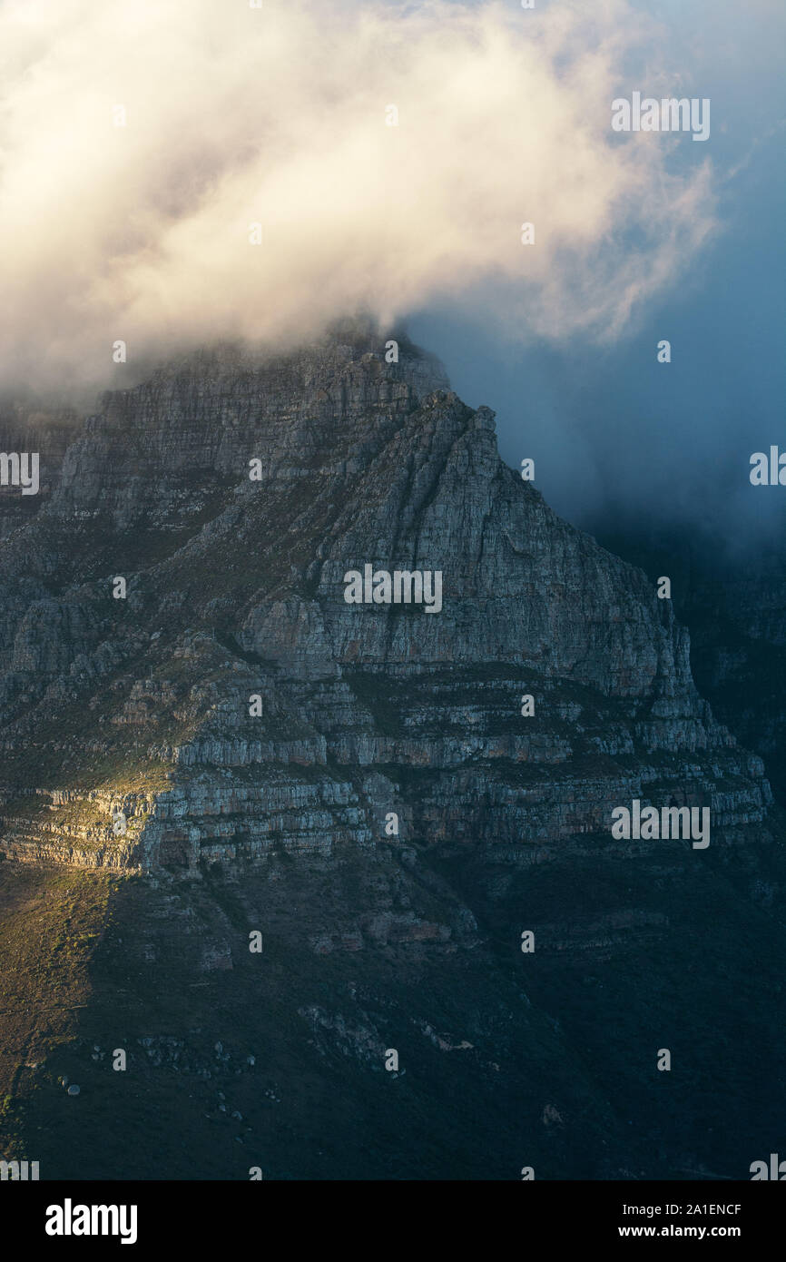 La Table Mountain di Città del Capo in Sud Africa coperto dalle nuvole comunemente conosciuto come la tabella di stoffa come visto dalla parte superiore della testa di leone montagna a sunrise Foto Stock