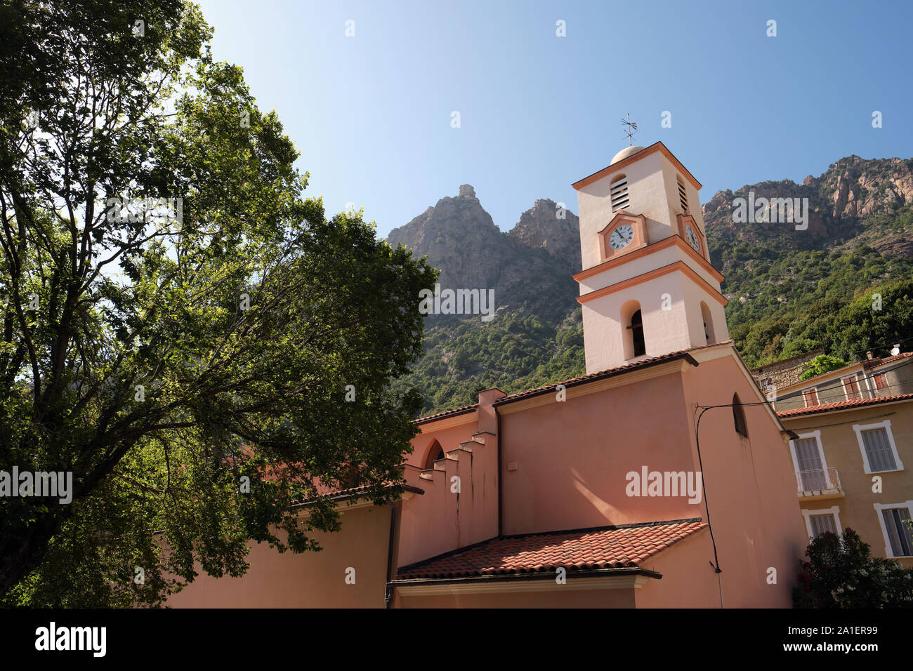 Ota villaggio chiesa e le vette e creste paesaggio di Capo d'Ota in Ota / Porto Regione, Corse-du-Sud, Corsica, Francia Foto Stock