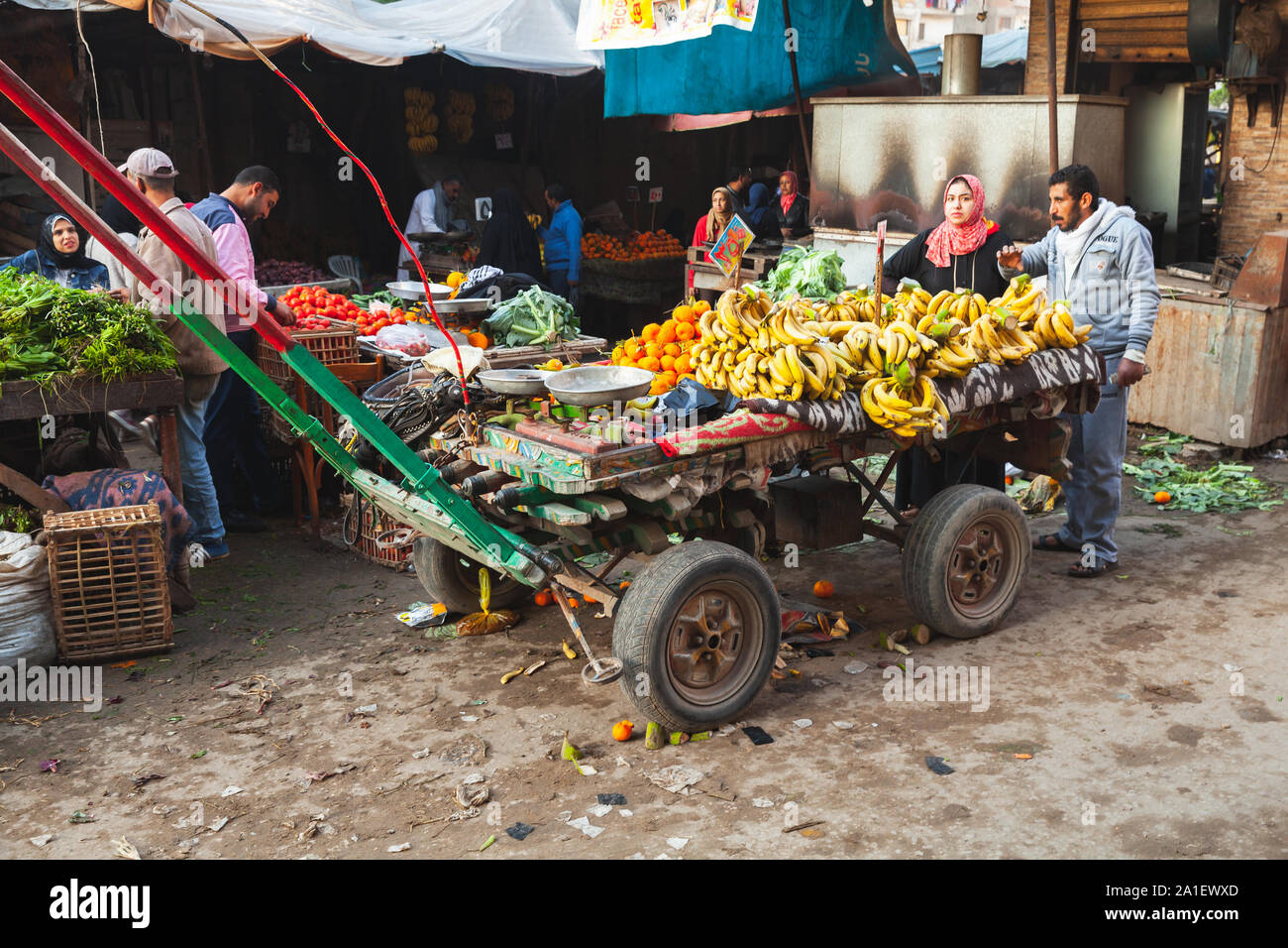 Alessandria, Egitto - 18 dicembre 2018: gli agricoltori egiziani sono vicino a cavallo di legno disegnati carrello pieno di frutti locali Foto Stock