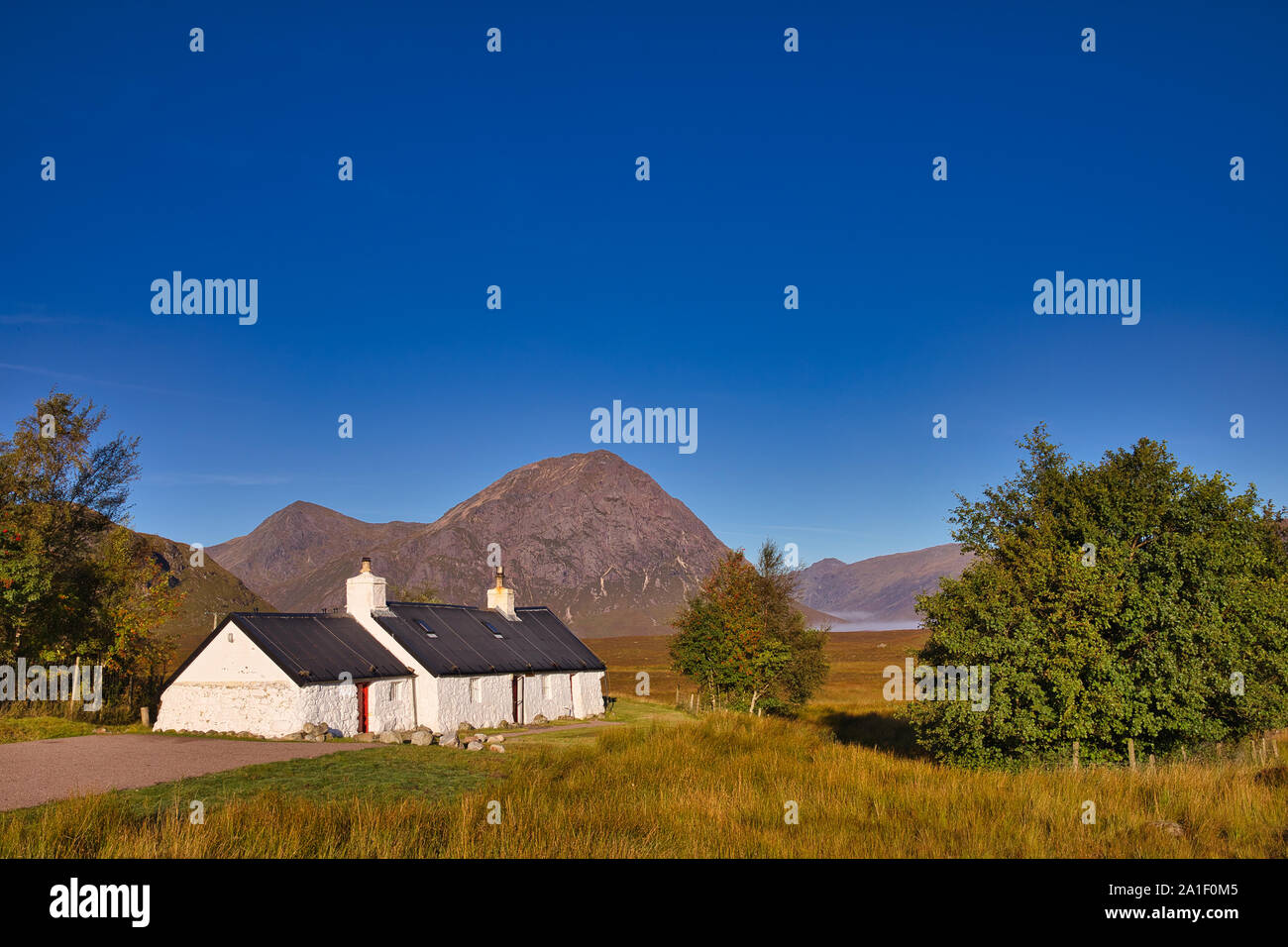 Black Rock Cottage e Buachaille Etive Mor, giornata di sole, cielo azzurro, Rannoch Moor, Glencoe, regione delle Highlands, Scozia Foto Stock