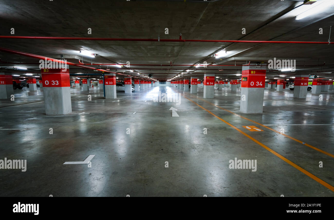 Svuotare il parcheggio sotterraneo molto. Parcheggio sotterraneo garage al centro commerciale o un aeroporto internazionale. Area parcheggio interna. Basamento in cemento Foto Stock