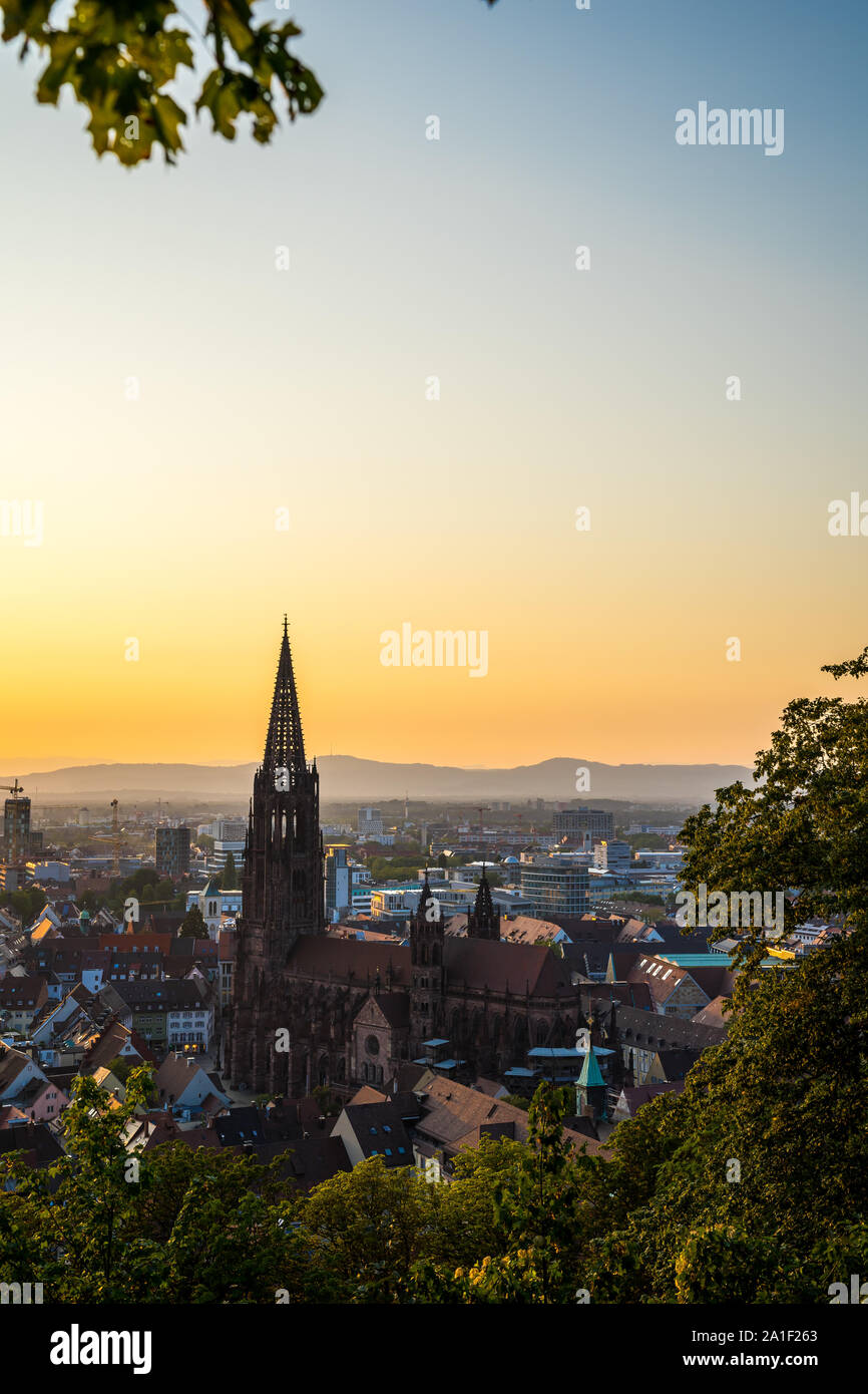 Germania, arancione tramonto cielo sopra il vecchio centro cittadino di città in città Freiburg im Breisgau a Baden nel periodo estivo visto da sopra Foto Stock