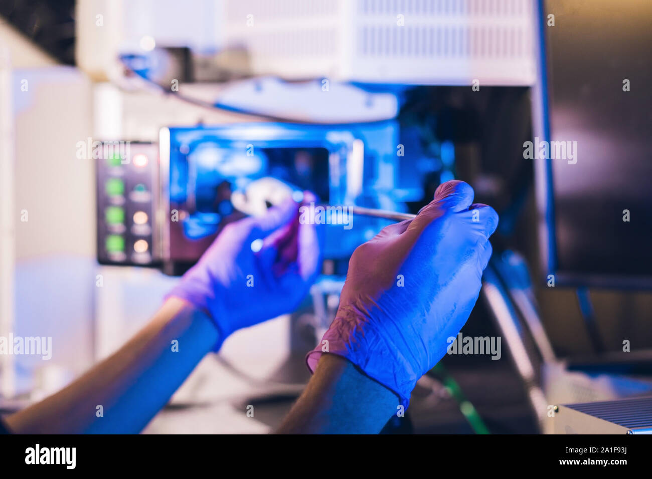 Scienziato in un laboratorio funziona con un microscopio elettronico gateway. Porre un campione in una camera. Foto Stock