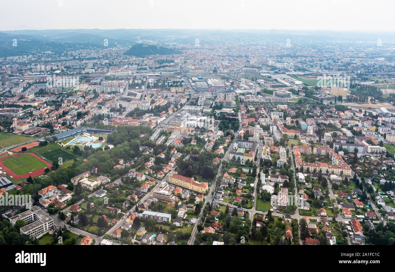 Vista aerea della città di Graz da elicottero drone con il distretto Eggenberg con piscina in un nuvoloso giorno di estate in Austria, Europa Foto Stock