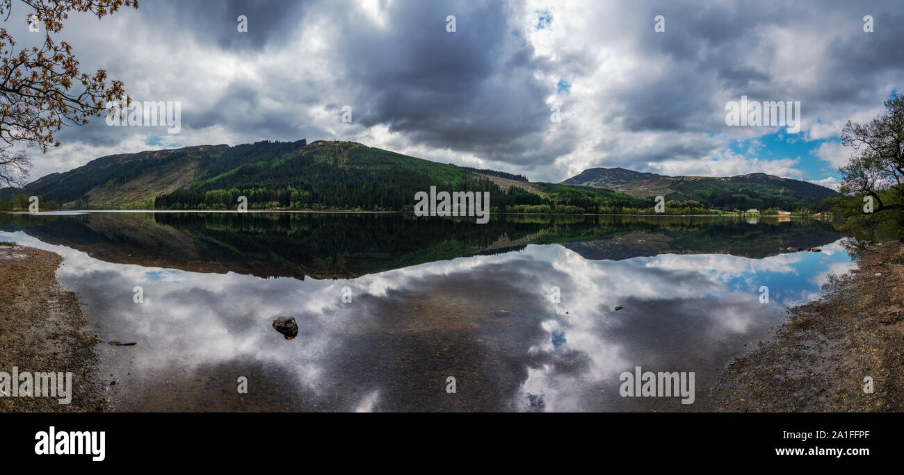 Il tempo era così tranquillo che un perfetto specchio è stato creato presso la scottish loch Foto Stock