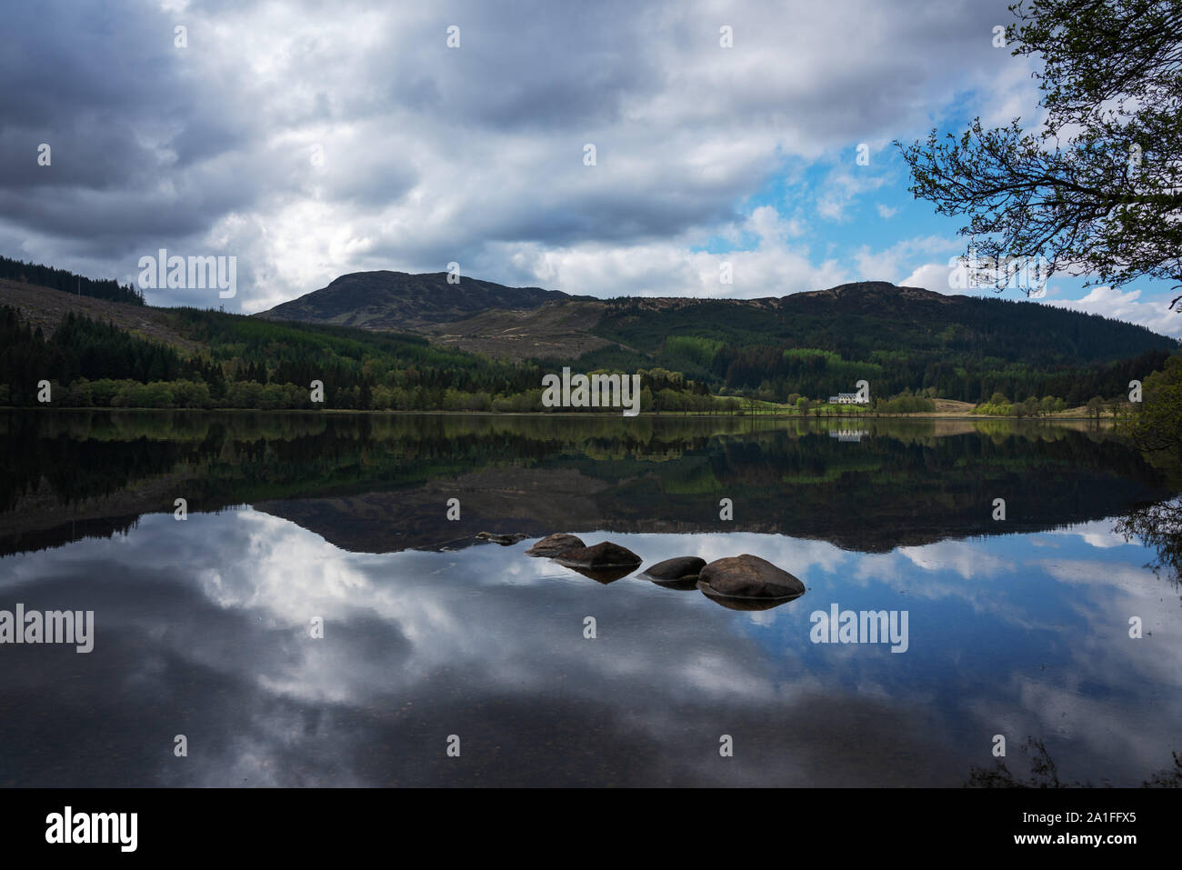 Il tempo era così tranquillo che un perfetto specchio è stato creato presso la scottish loch Foto Stock