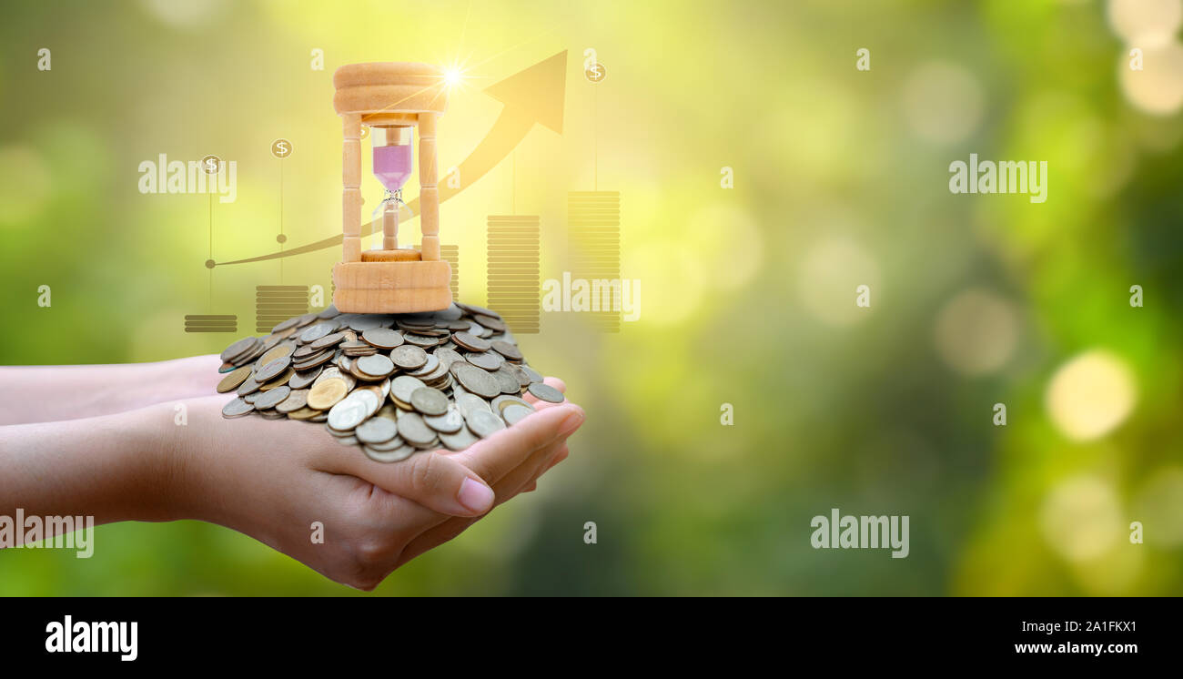 Monete d'argento e Clessidra e finanziario i concetti di business e di utilizzo di tempo Foto Stock