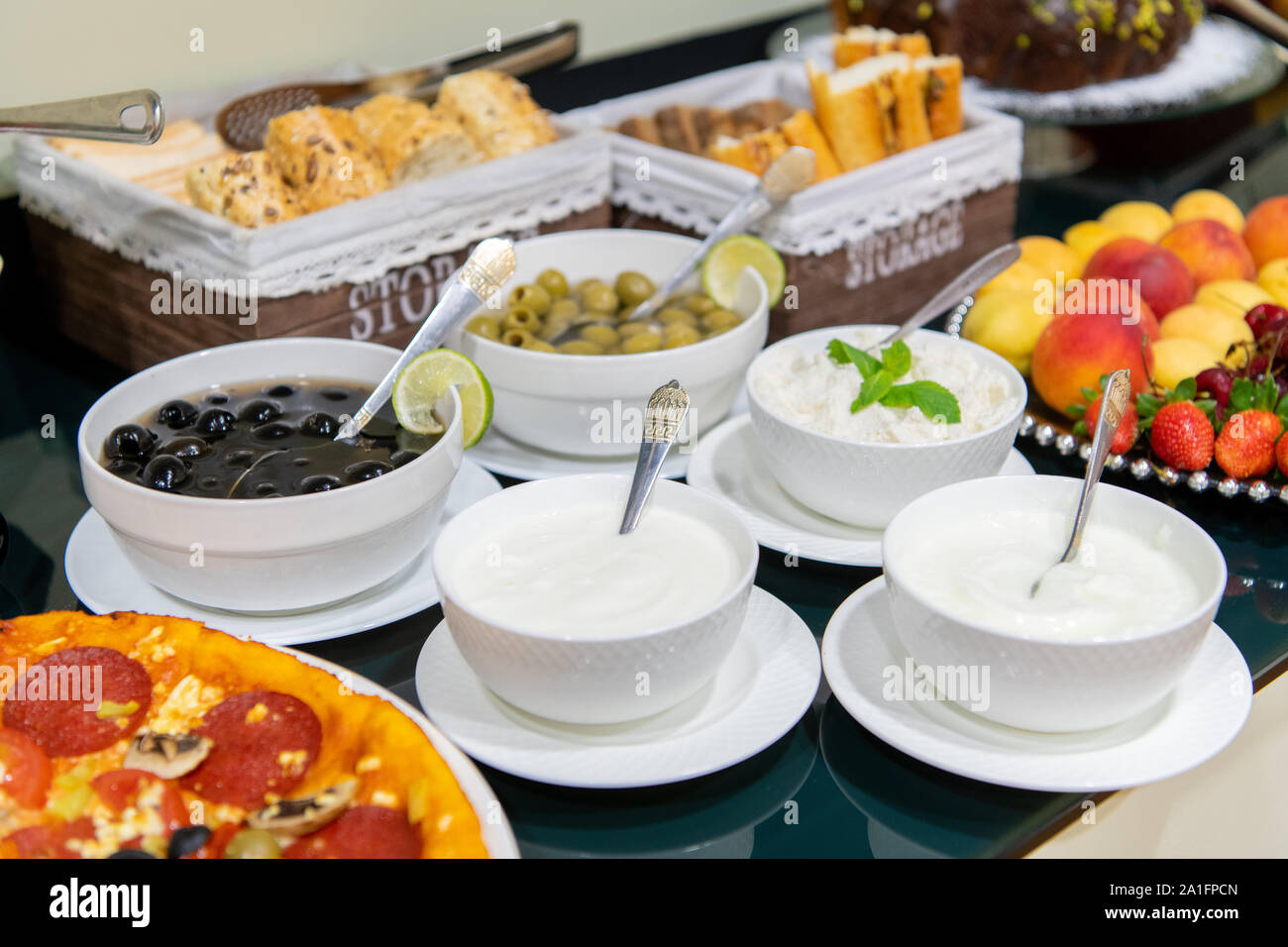 Una selezione di salse, olive, latticini e contorni a buffet al bancone di un ristorante. Foto Stock