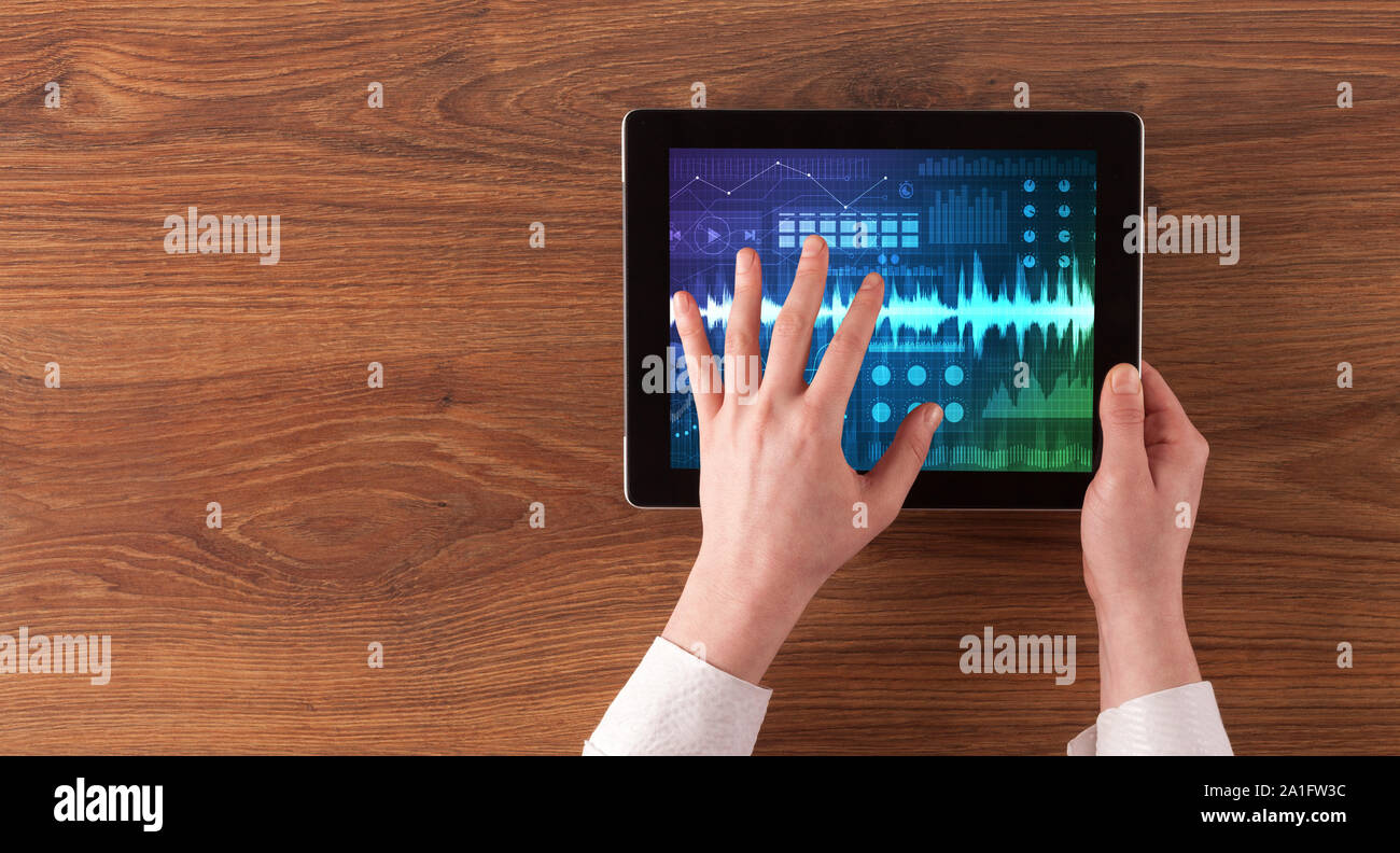 Mano toccando tablet con forme d'onda e sound design concept Foto Stock