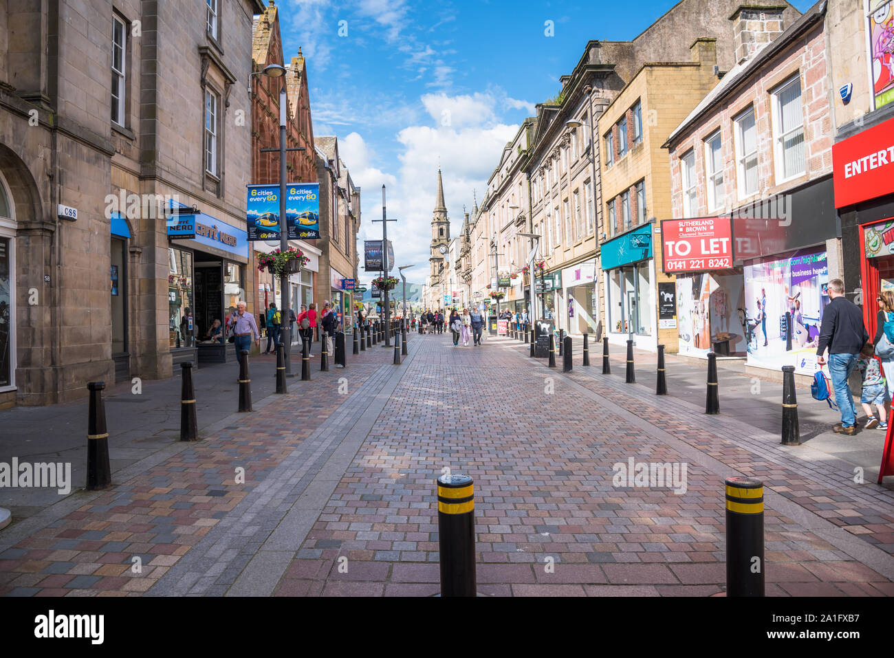 Ciottolo zona pedonale ricca di negozi e ristoranti a Inverness, Scotland, in una giornata di sole Foto Stock