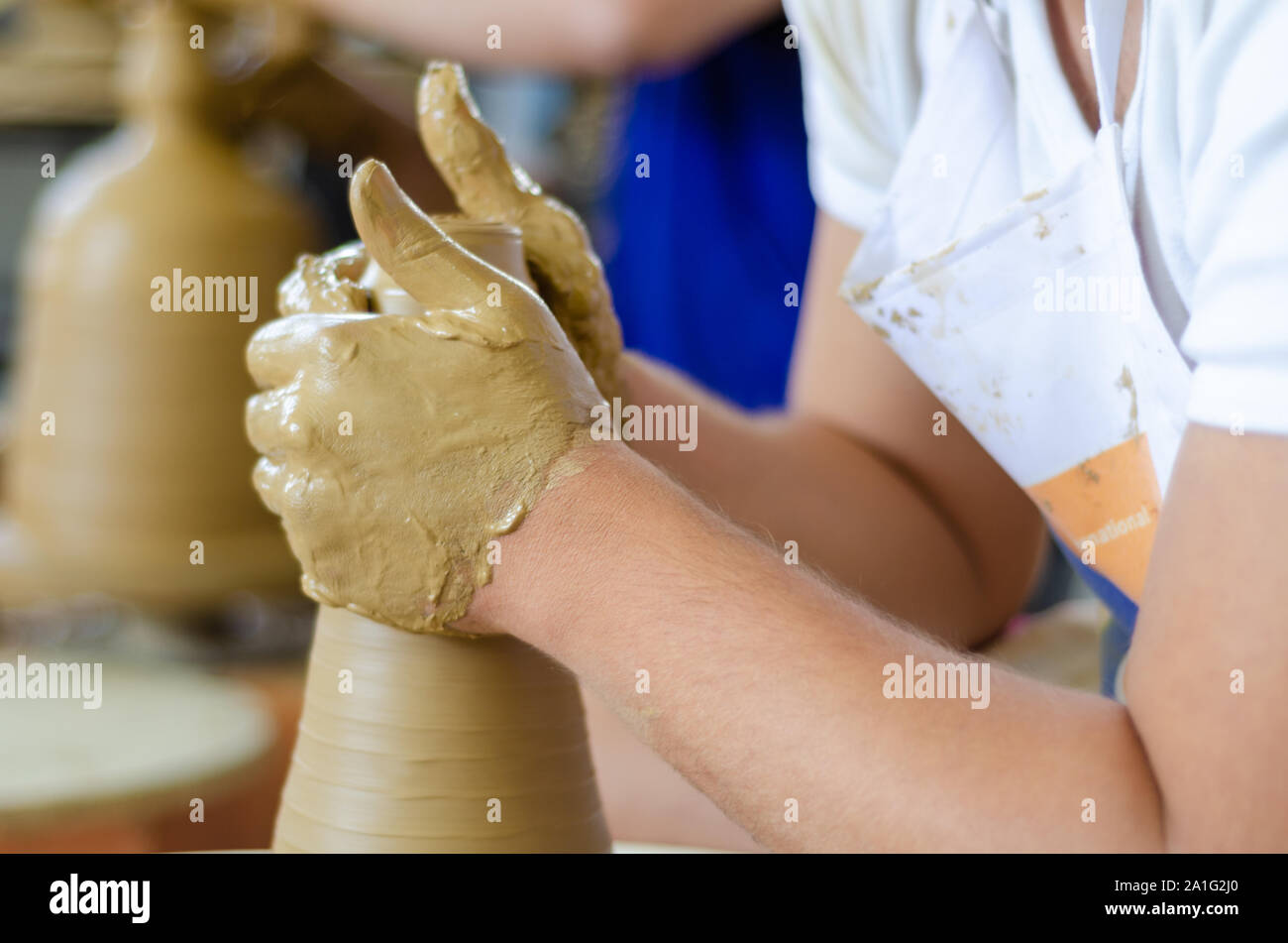 Ceramica processo di lavoro con argilla tornio del vasaio, vicino. L'uomo è fare ceramica in studio. Foto Stock