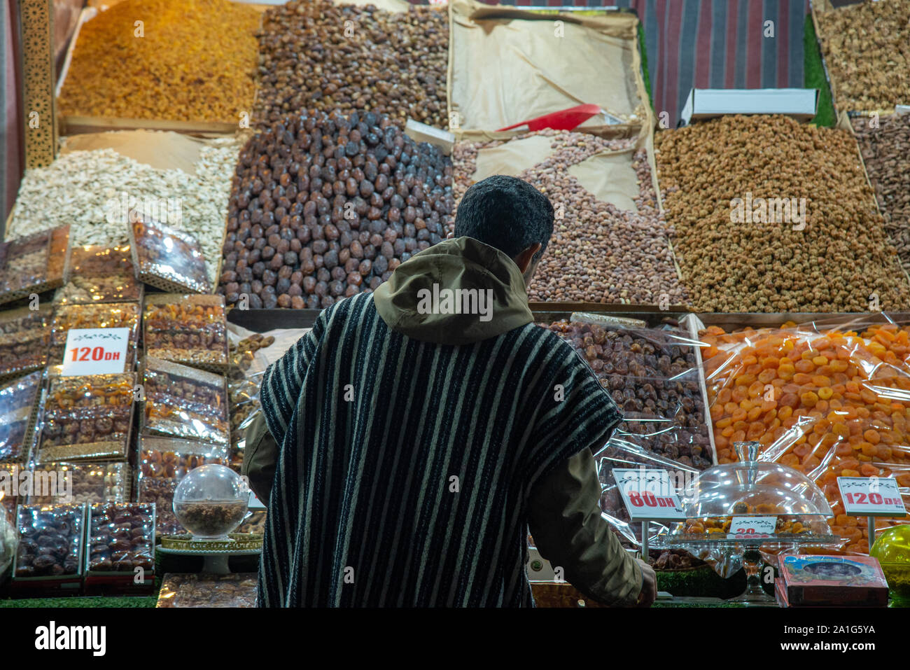 Uomo in djellaba vendita di frutta secca e noci a piazza Jemaa el Fna a Marrakech in Marocco Foto Stock