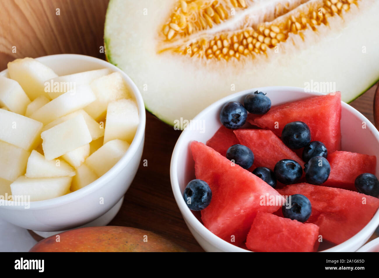 Anguria, zucchero melone e mirtilli fette nella ciotola sul tavolo Foto Stock