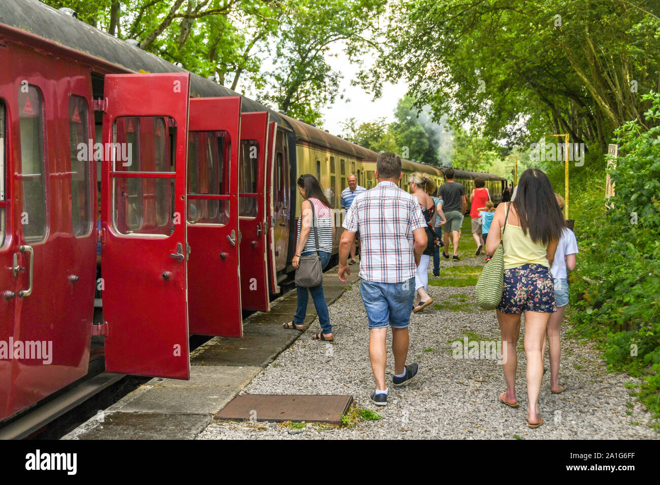 CRANMORE, Inghilterra - Luglio 2019: persone tornare indietro a piedi per la stazione di campagna stazione di arresto alla fine della linea sulla East Somerset Railway. Foto Stock