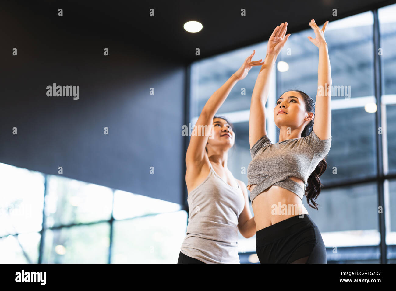 Bella donna asiatica di apprendimento pongono yoga con istruttore femmina in studio di yoga o di un club salute. Sport esercita attività, la ginnastica o la danza di balletto Foto Stock