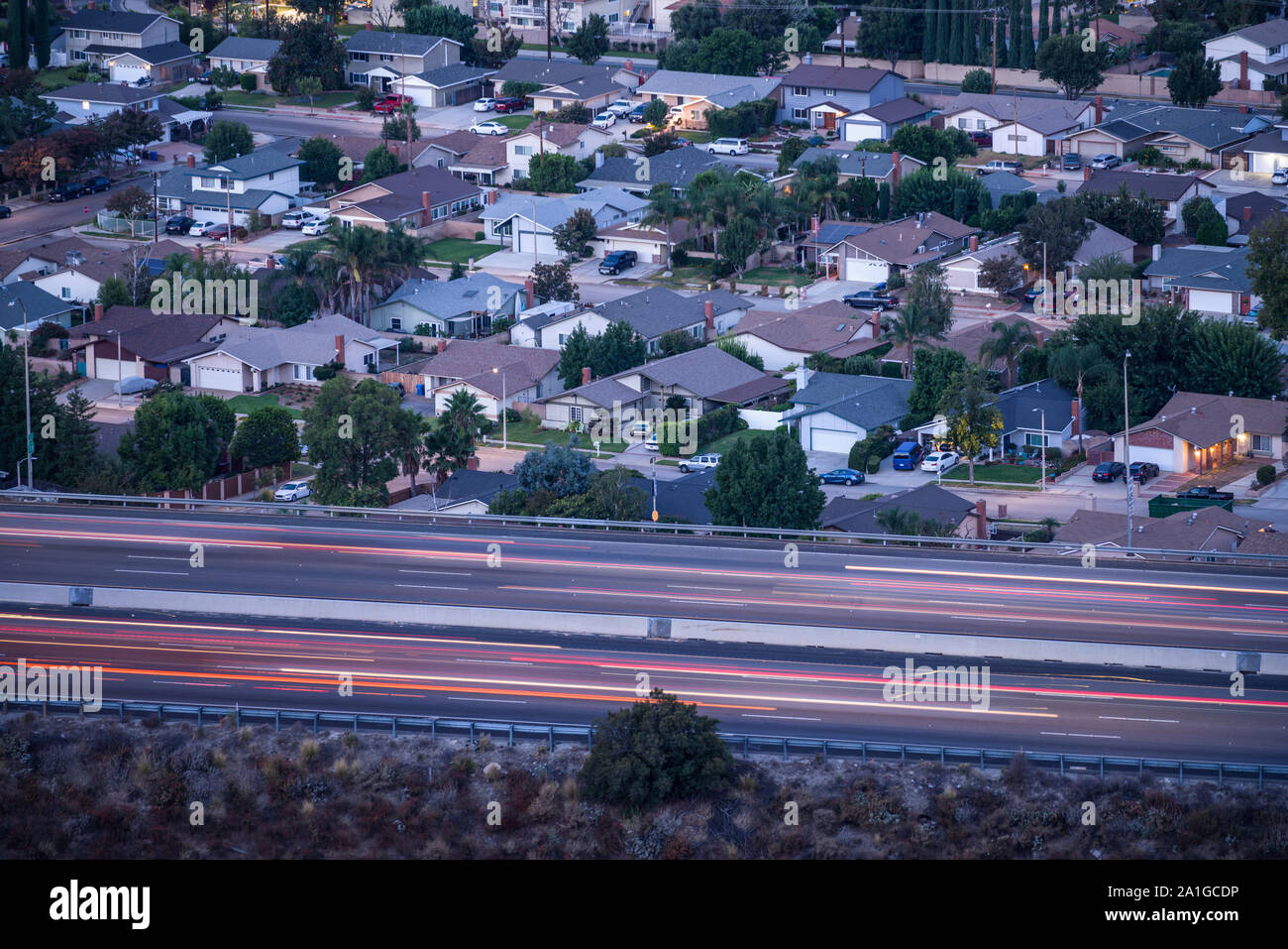 Vista Predawn di case di periferia e il commuter freeway traffico nei pressi di Los Angeles in Simi Valley, California. Foto Stock