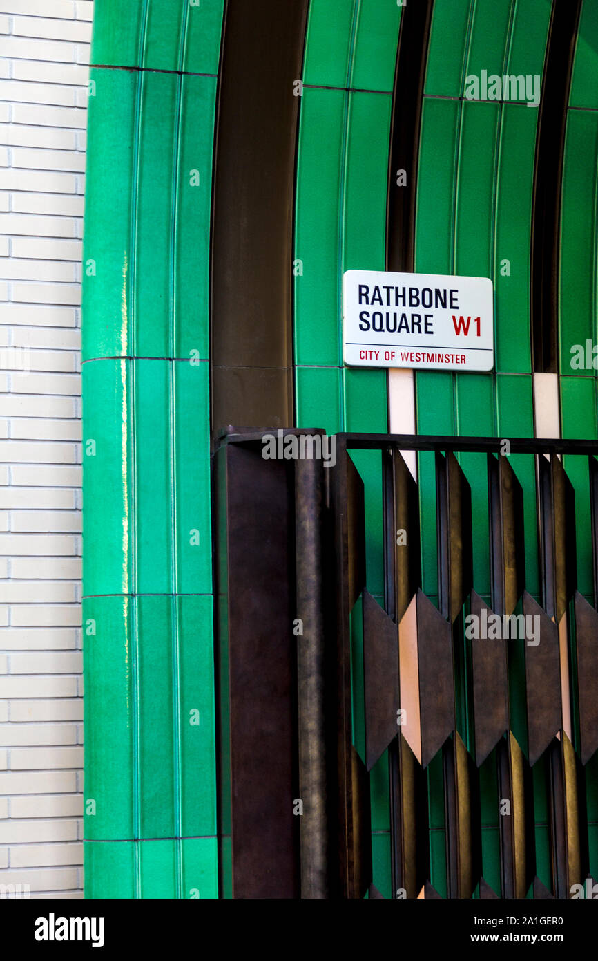 Cartello stradale targa per Rathbone Square, smaltate di piastrelle di ceramica e di un cancello di ottone disegnati dall'artista Robert Orchardson, Tottenham Court Road, Londra, Regno Unito Foto Stock