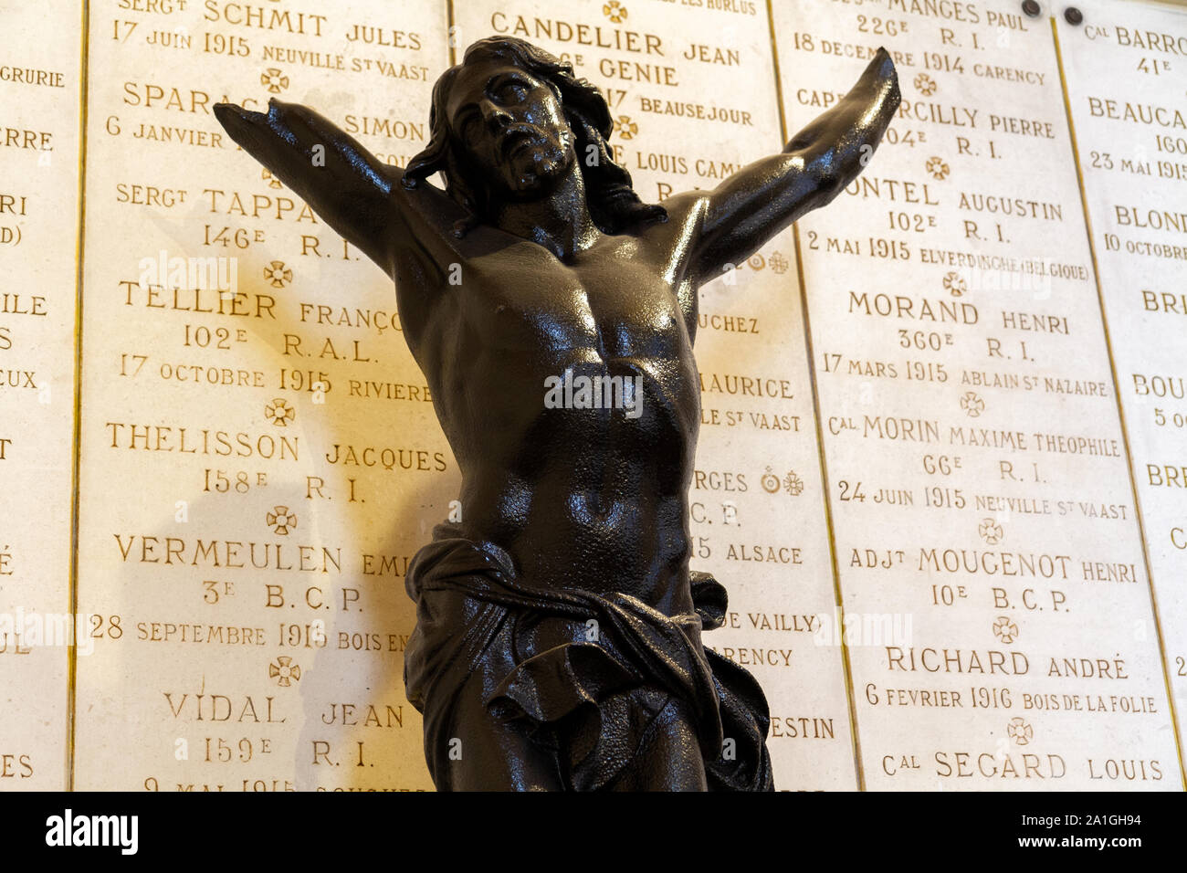 Placche con i nomi dei soldati caduti in WW I. rotto statua di Gesù di fronte a loro. Chiesa di Notre-Dame-de-Lorette presso il Memorial di WW I (1914-18). Foto Stock