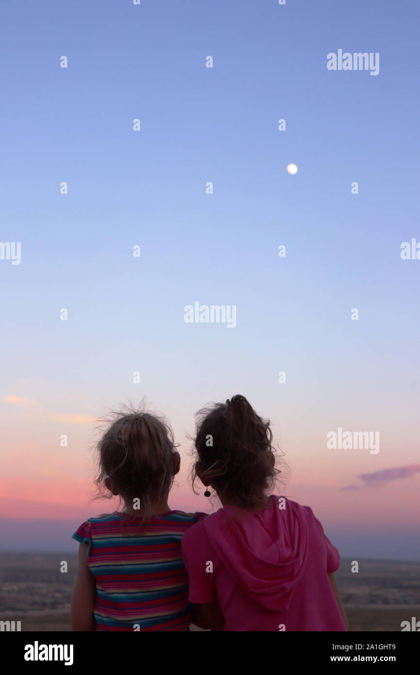 Due ragazze che godono il tramonto e la luna su El Paso, Texas Foto Stock