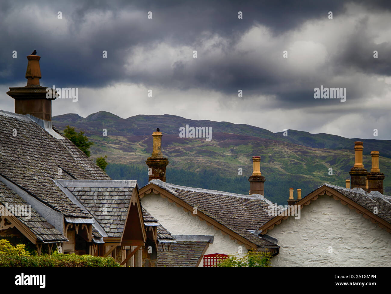 Cielo tempestoso al di sopra del villaggio di Loch Lomond nelle Highlands Scozzesi. Si tratta di un splendido piccolo villaggio! Foto Stock