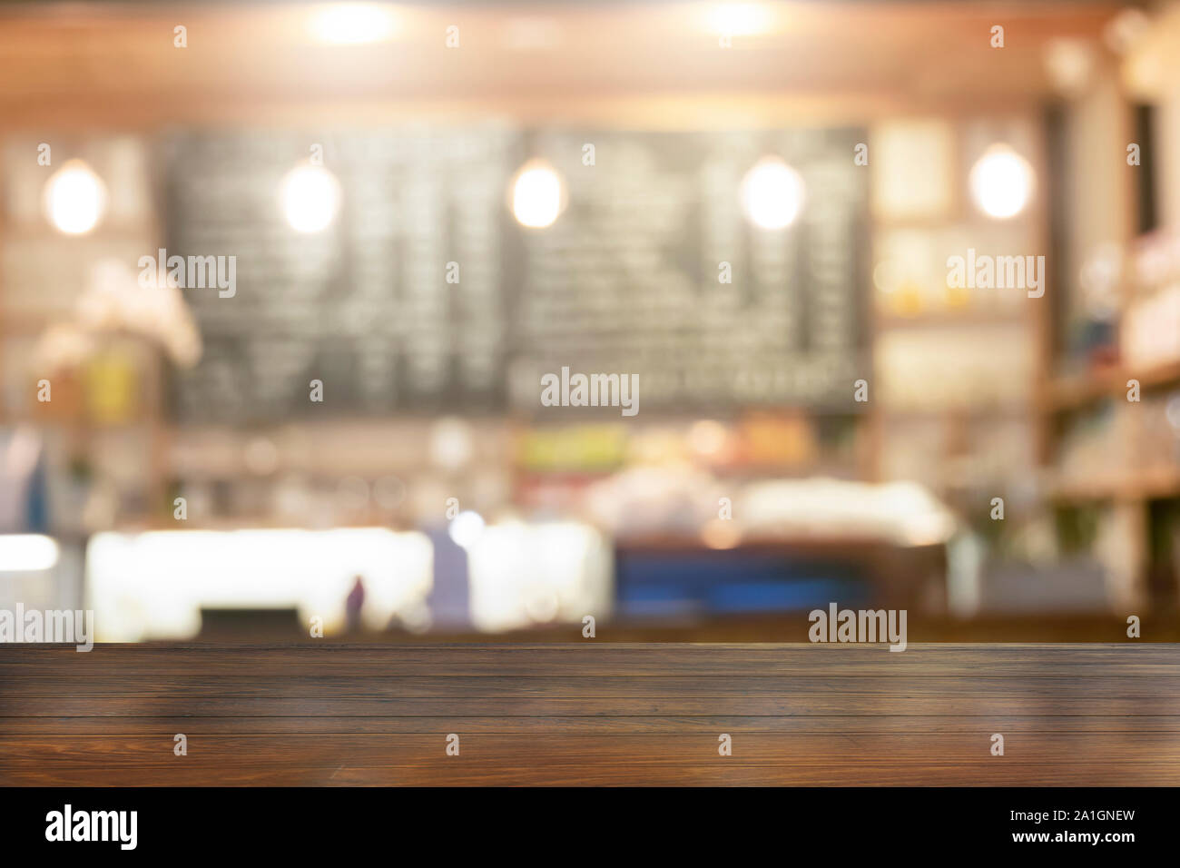 Tavolo in legno top con vista offuscata bevande Caffe bar sullo sfondo Foto Stock