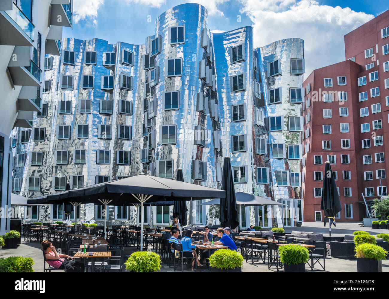 Il Gerry edifici a Düsseldorf Media Harbour spiralizza e stretching nel cielo in architetto americano Frank O. Gehry iconico stile, loro mirrore Foto Stock