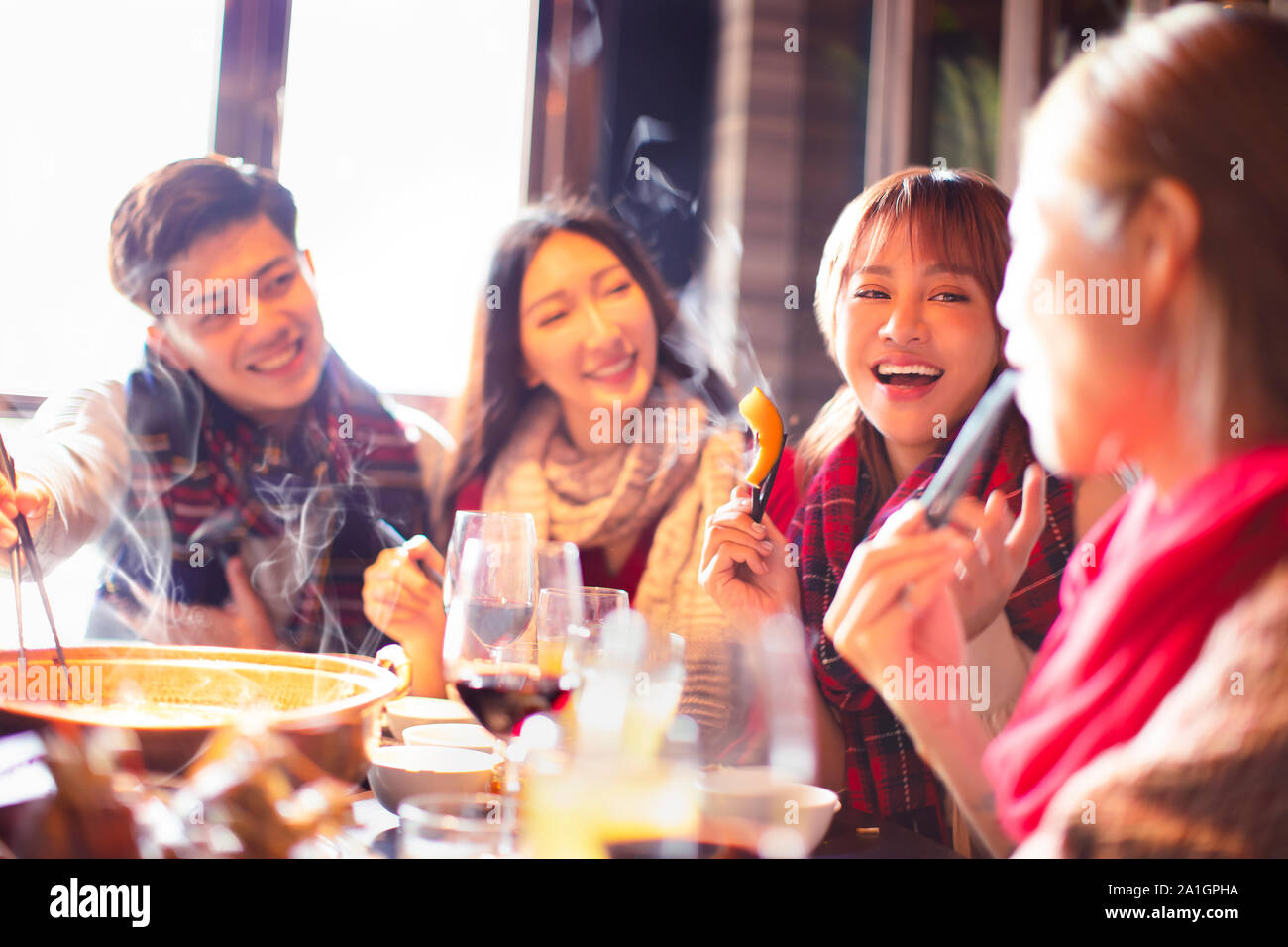 Felice giovani amici di mangiare hot pot in ristorante in inverno Foto Stock