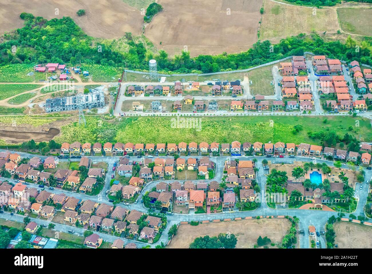 Vista aerea del nuovo alloggiamento suddivisioni nelle Filippine, come la crescita della popolazione le forze di espansione urbana in terreno agricolo vicino sull'isola di Luzon. Foto Stock