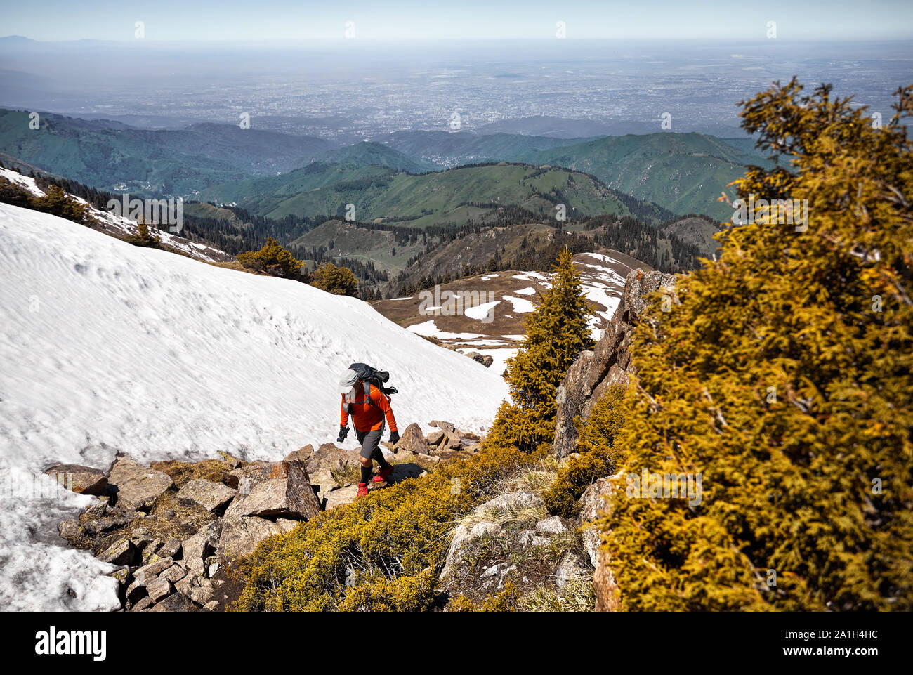Turisti in maglietta arancione con zaino passeggiate in montagna. Esterno il concetto di viaggio Foto Stock