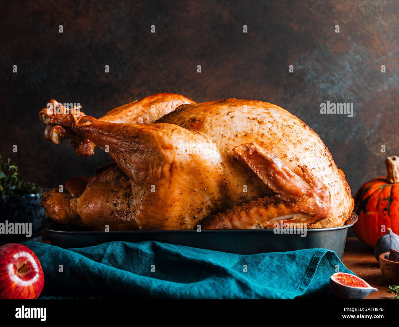 Arrosto di tacchino intero su un tavolo con Apple, la zucca e le figure per la famiglia per la Festa del Ringraziamento. Foto Stock