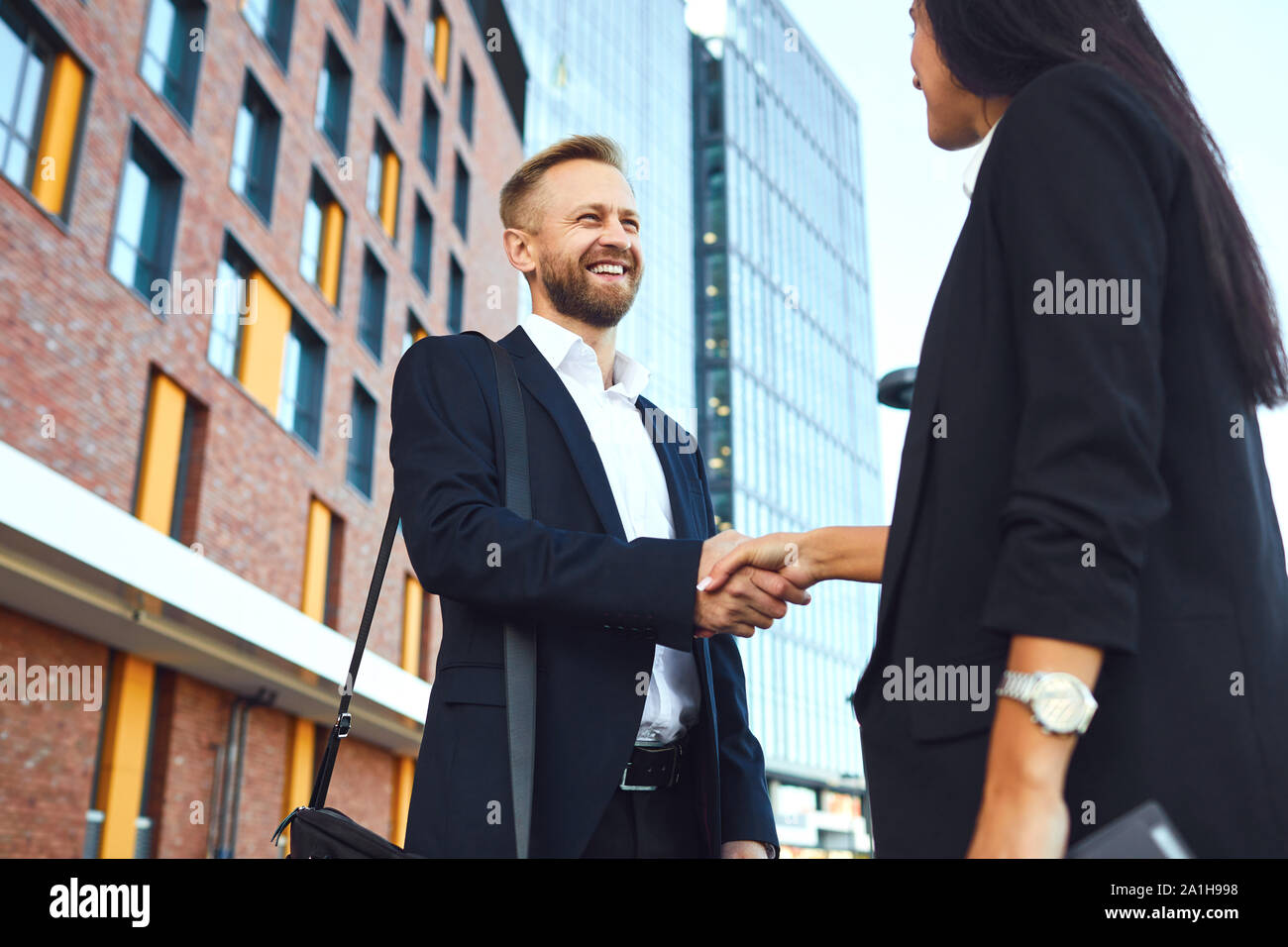 Business di handshake. Imprenditore e business donna fanno strette di mano mentre in piedi all'aperto Foto Stock