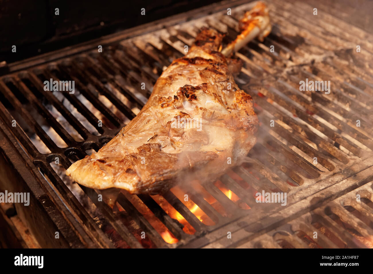 La gamba di agnello fritto essendo sulla griglia a carbone Foto Stock