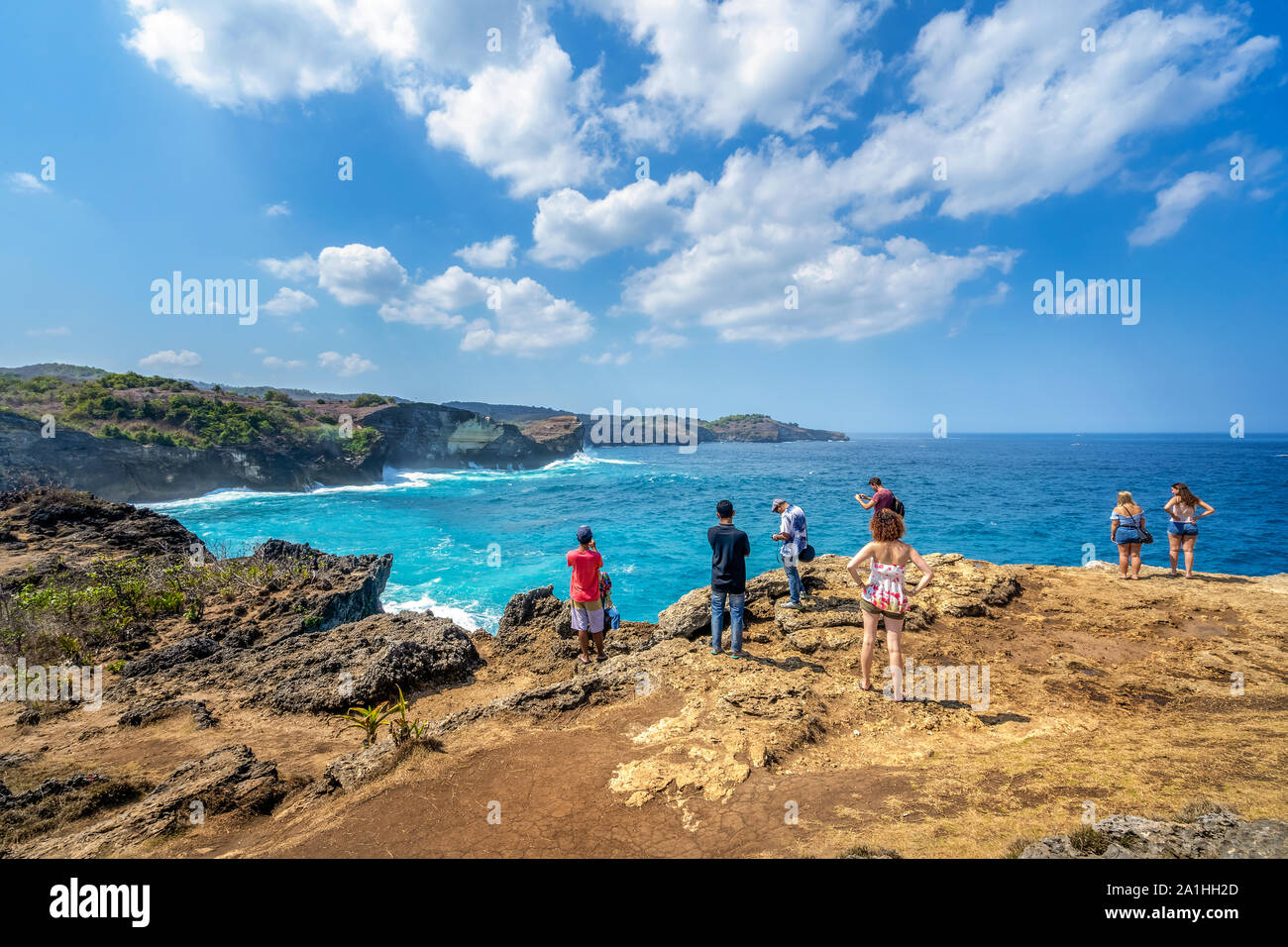 La gente di viaggio con zaino e in pantaloncini corti sull'oceano, scogliere e spiaggia tropicale sfondo. Angelo Billabong, Spiaggia di Nusa Penida, Indonesia. Foto Stock