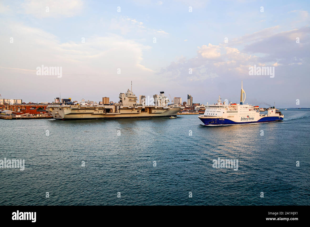 Brittany Ferries car e passeggero traghetto RoPax Baie de Seine arrivando a Portsmouth Hampshire REGNO UNITO Inghilterra con portaerei Queen Elisabeth ormeggiati Foto Stock