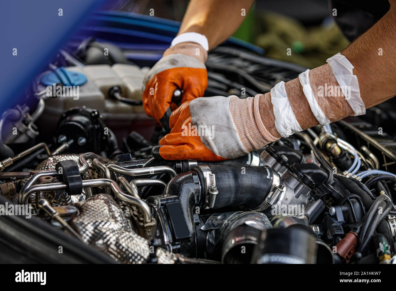 Officine meccaniche la riparazione di un motore di automobile. l uomo che fissa il motore auto. Il servizio e la manutenzione. Foto Stock