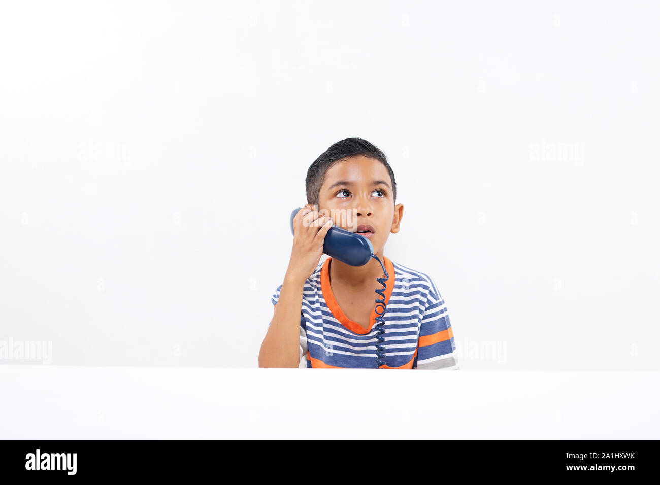 Carino piccolo ragazzo parlando al telefono su rete fissa Foto Stock