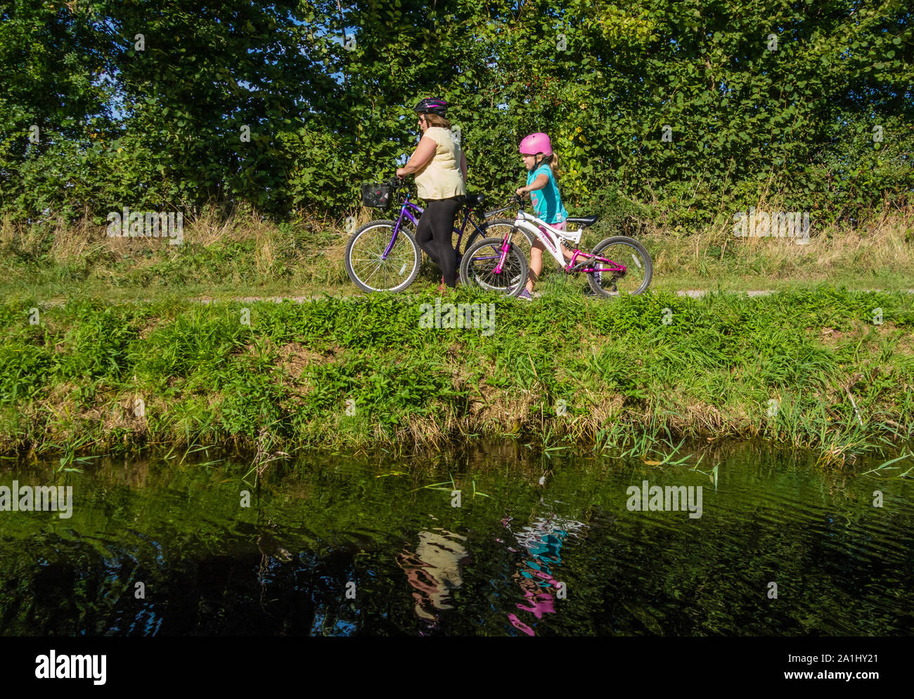 La madre e il bambino in bicicletta sul Grand Canal occidentale alzaia, Devon, Inghilterra, Regno Unito. Foto Stock