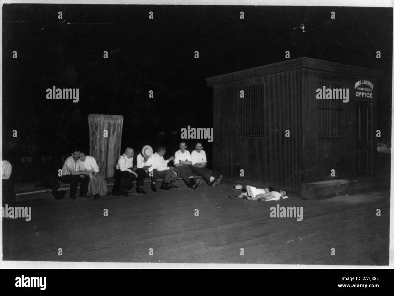 N.Y.C. - La gente seduta sul molo di notte durante la stagione calda, 2 bambini piccoli dormire Foto Stock