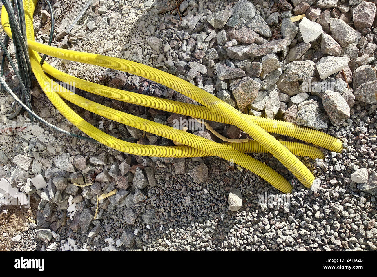 Il giallo di tubi per cavi elettrici o incollaggio di acqua dal suolo al sito in costruzione. Foto Stock