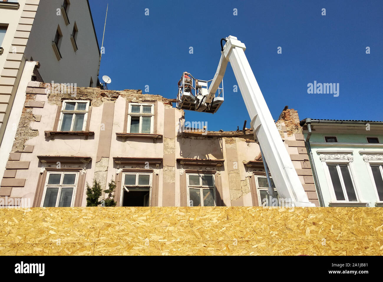 Torre della gru di sollevamento e vecchio edificio sotto lo smantellamento. Foto Stock