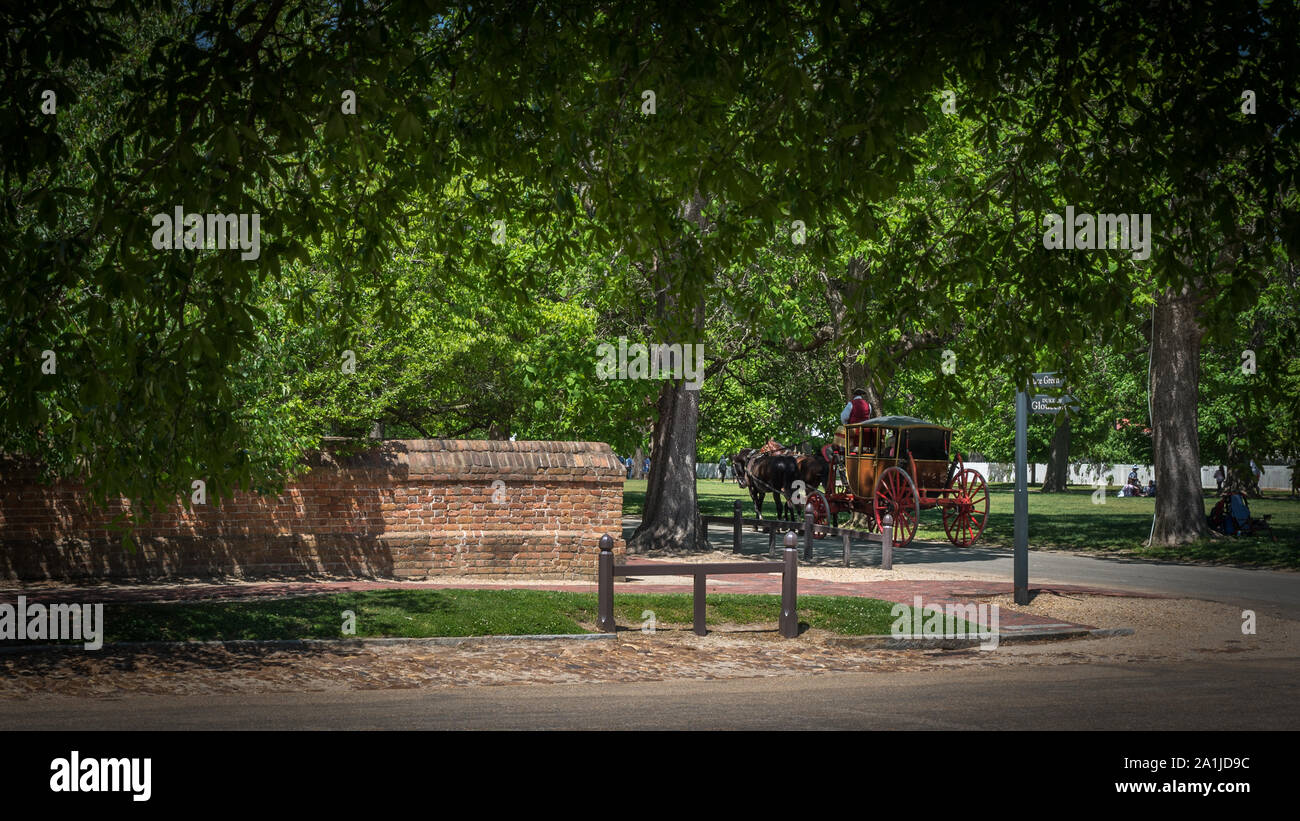 Carro trainato da cavalli azionato da uomo in costume coloniale in viaggio verso il basso Williamsburg Road Foto Stock