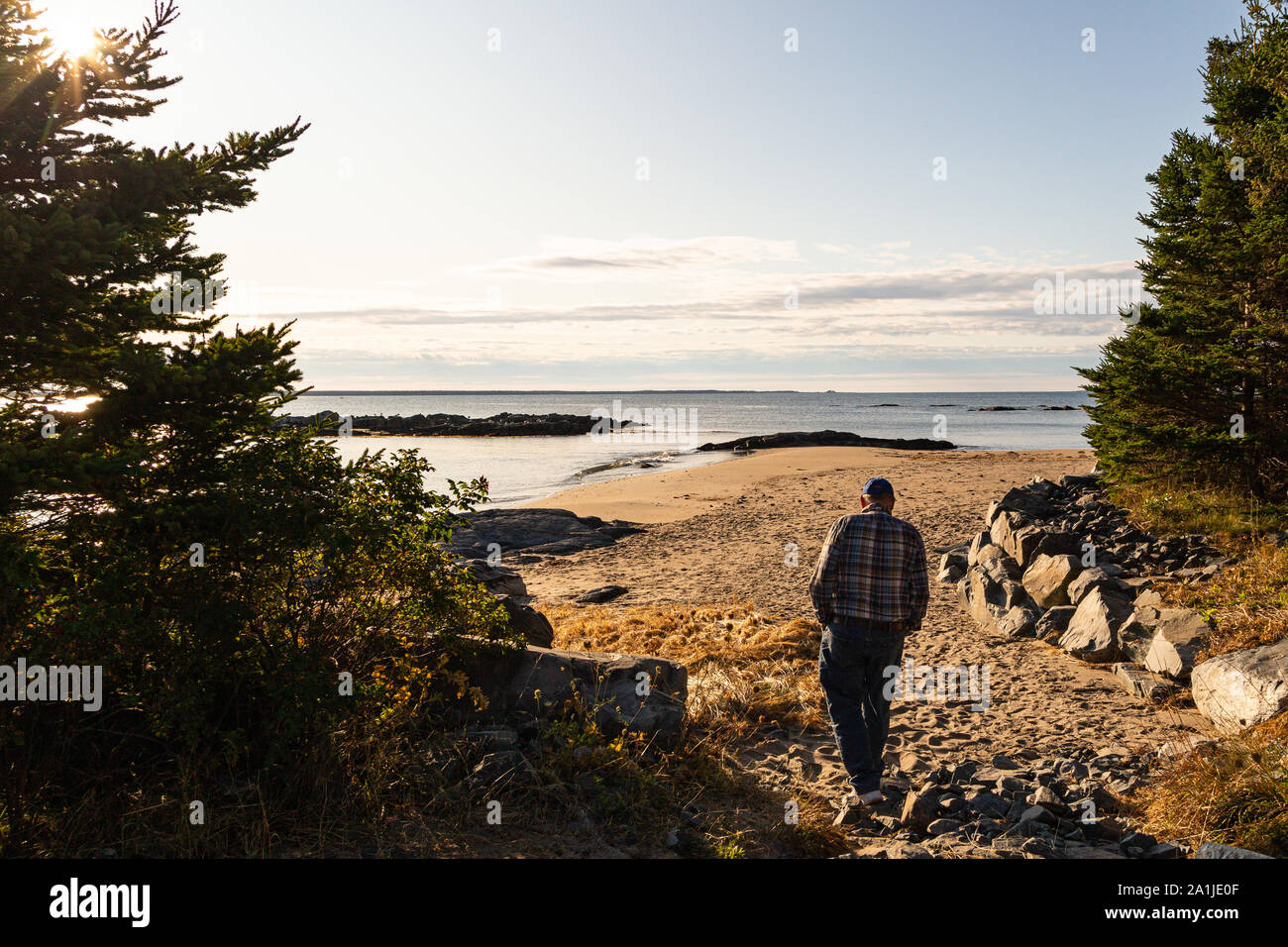 Senior gentleman andando per un inizio di mattina passeggiata sulla spiaggia in Green Bay, Nova Scotia, Canada. Foto Stock
