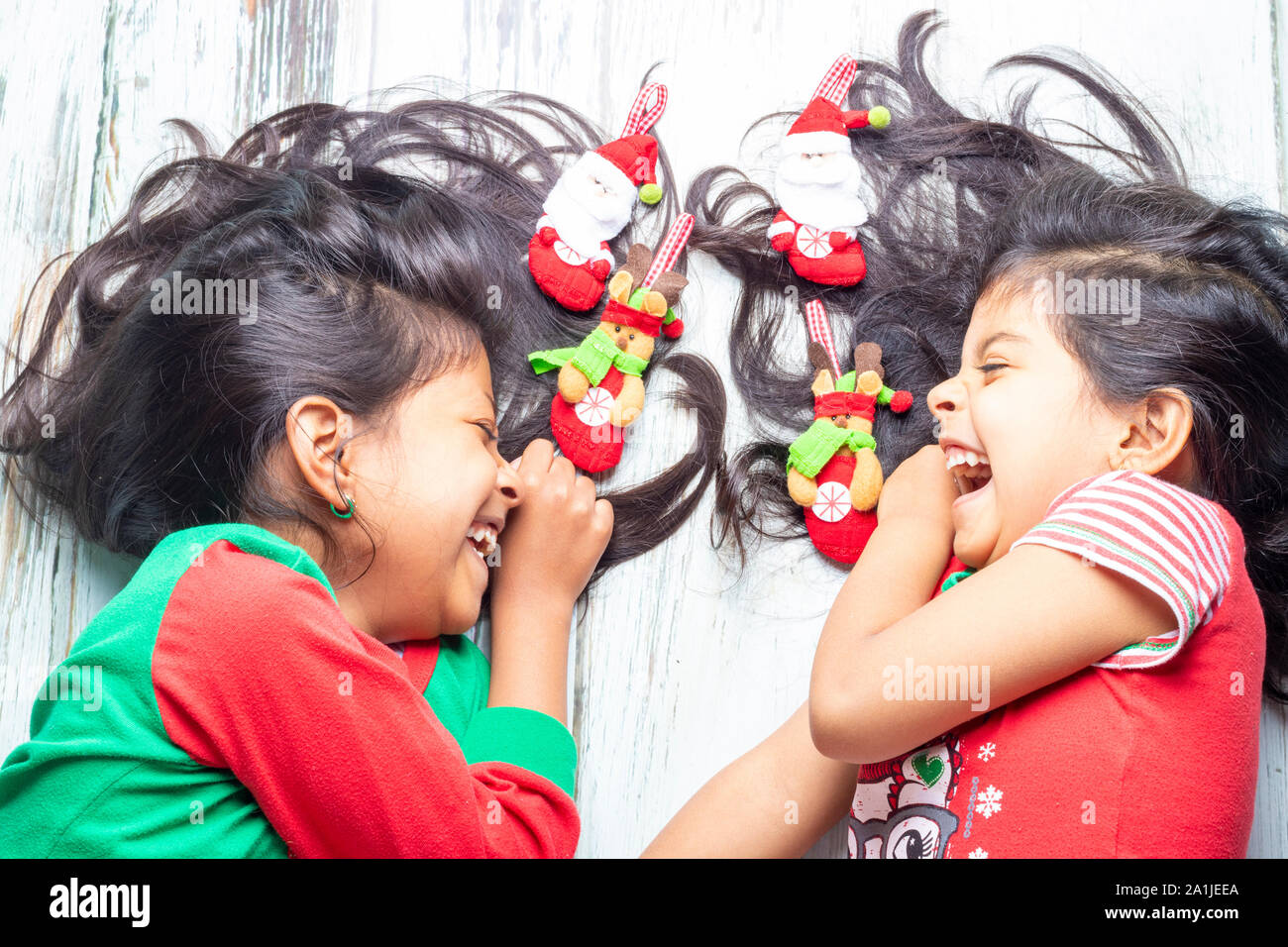 Sorridente sorelle decorare i loro capelli con decorazioni di Natale Foto Stock