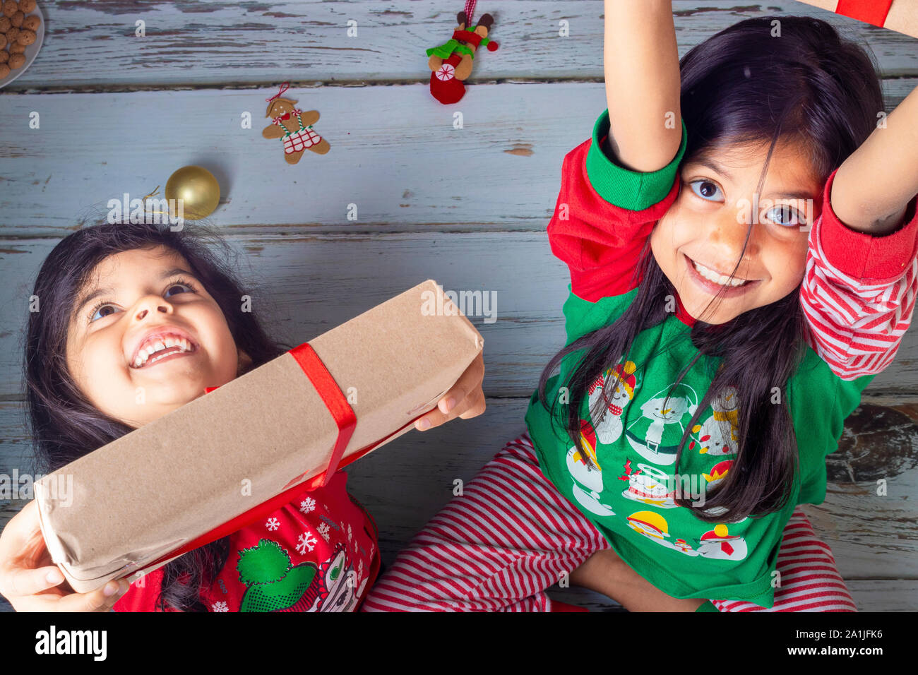 Piccole sorelle di aprire i loro doni il giorno di Natale Foto Stock