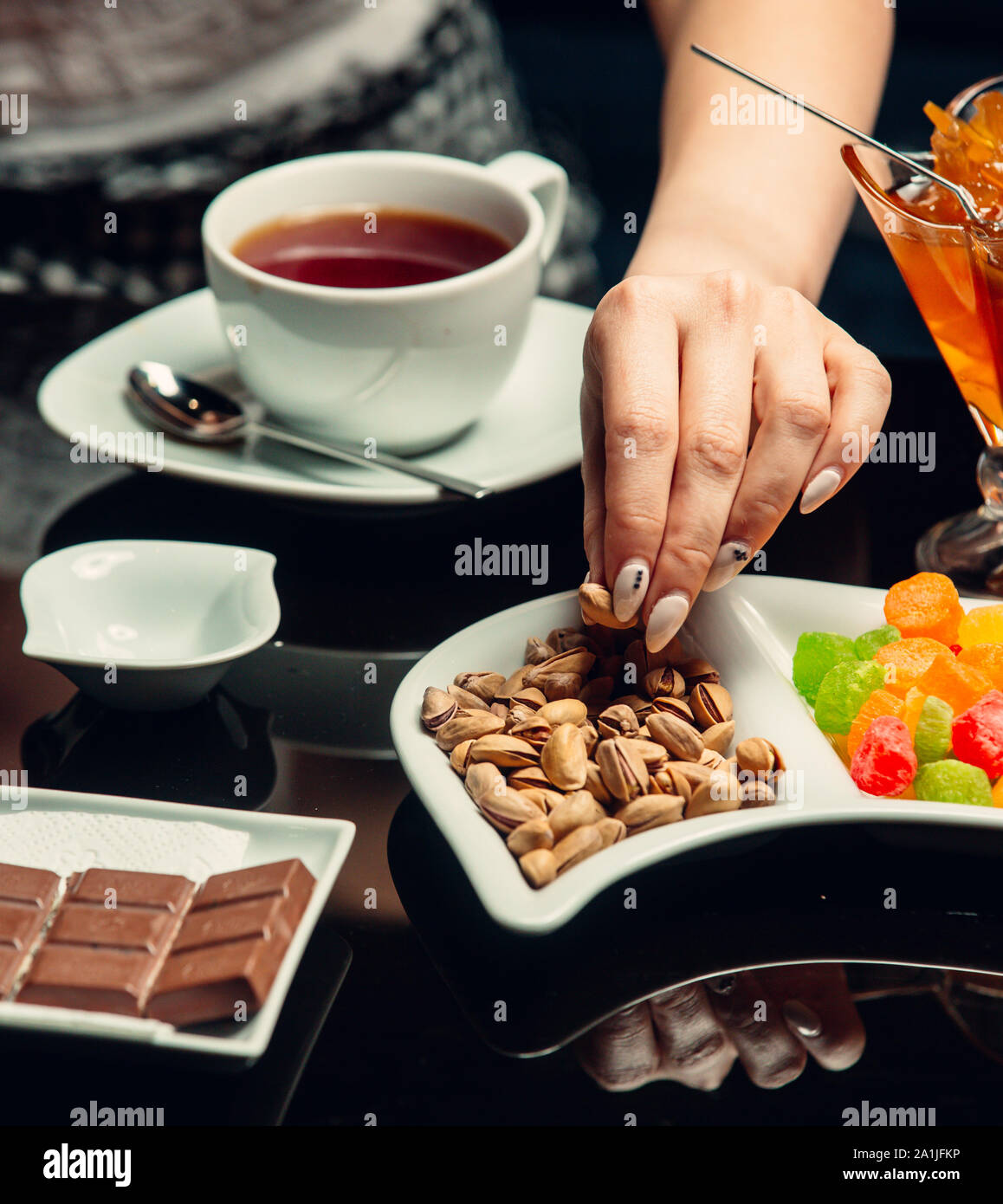 White tazza di tè serviti con cioccolato, pistacchio Foto Stock