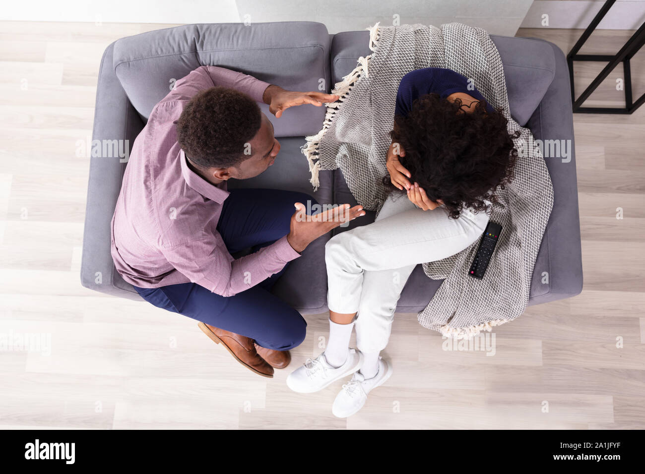 L uomo e la donna in comunicazione con le lingue gestuali seduto sul divano Foto Stock