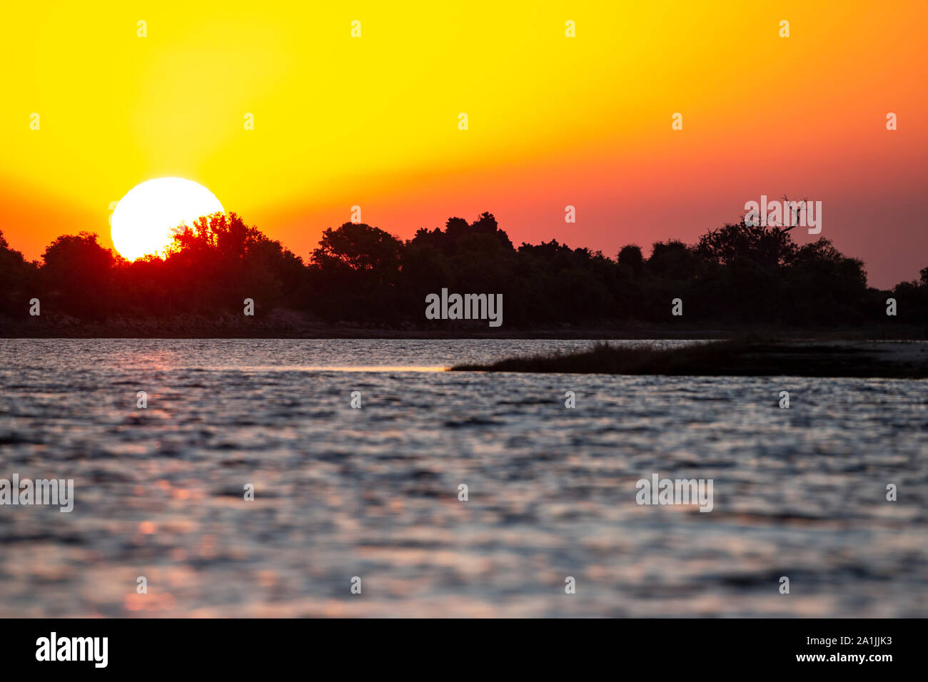 Ricco di colore arancione e oro tramonto sul fiume Chobe in Botswana come il sole scende Foto Stock