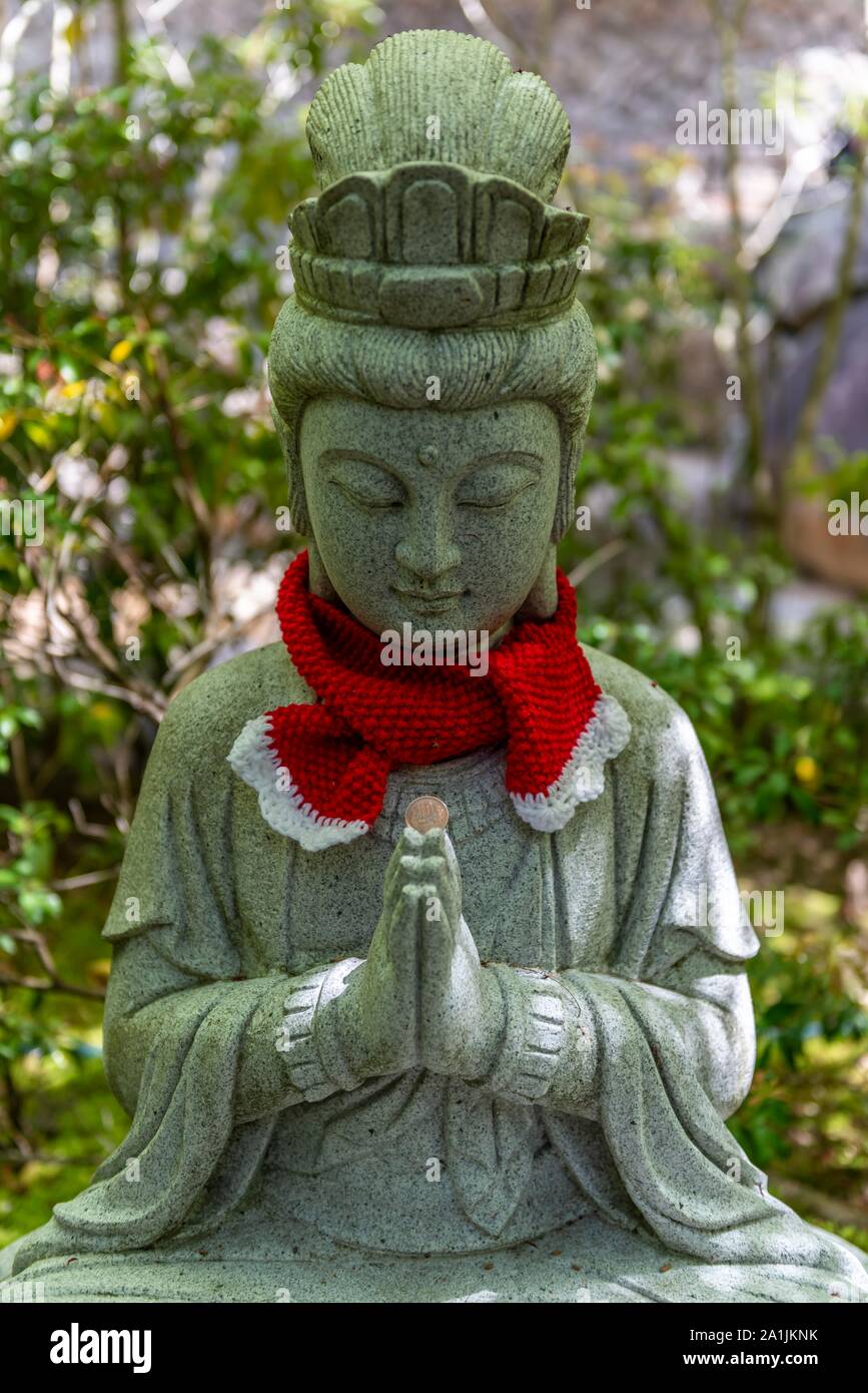 Statua del Buddha con cappucci colorati, Daisho-nel complesso tempio, sull'isola di Itsukushima, Miyajima, Baia di Hiroshima, Giappone Foto Stock